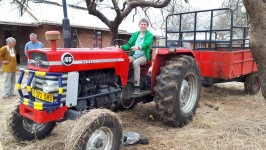 Matthias sitzt zur Probe auf dem neuen Traktor